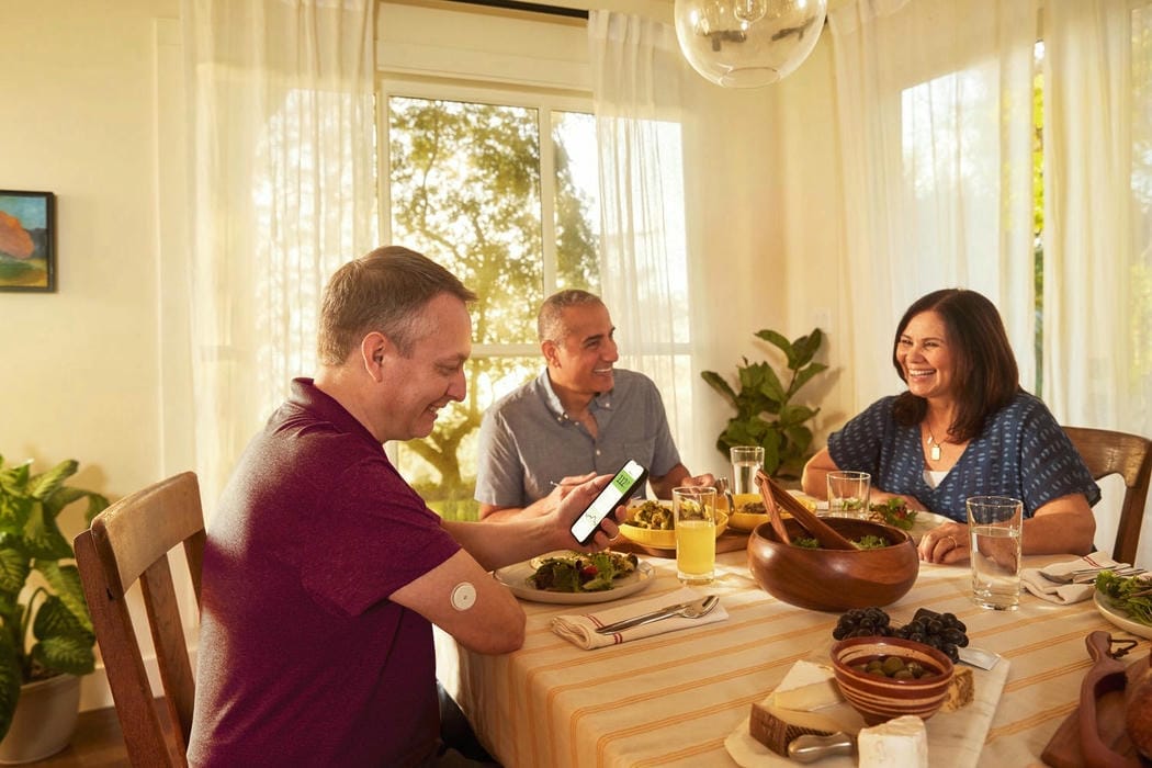 Una familia en la mesa del comedor comiendo y conversando.